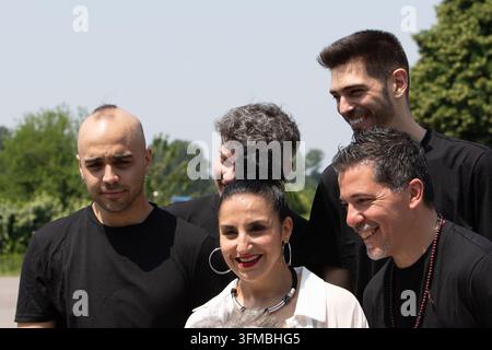 Gruppo diversificato di persone in piedi e sorridenti, che godono di una giornata soleggiata all'aperto Foto Stock