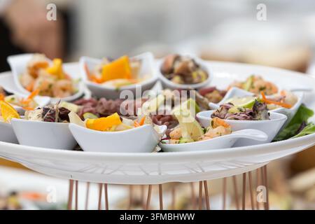 Vari appetiti di frutti di mare e finger food disposti su un vassoio per un evento Foto Stock