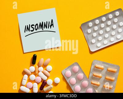 Raccolta di diverse pillole per dormire e compresse disposte intorno a un biglietto etichettato Insonnia. Trattamento dell'insonnia. Foto Stock