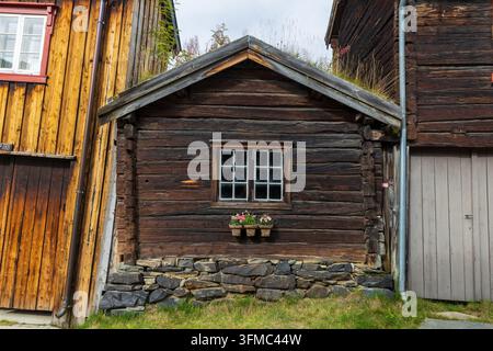 Architettura in legno tradizionale con muro di tronchi rustico e finestra in Norvegia Foto Stock
