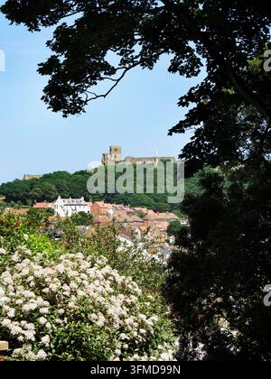 Castello di Scarborough e centro storico visti attraverso gli alberi a St Nicholas Gardens Scarborough North Yorkshire Inghilterra Foto Stock