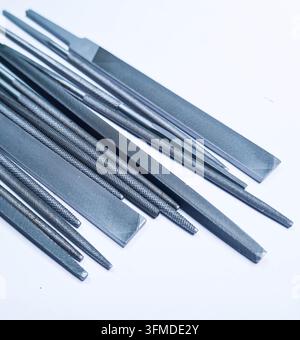 Vari lime metalliche di forme diversa disposte su uno sfondo bianco pulito, adatte per concetti industriali, da officina, artigianali e tecnici. Foto Stock