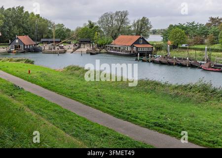 Woudrichem, Paesi Bassi. Area portuale storica panoramica con barche di legno tradizionali ormeggiate lungo gli edifici sul lungomare. Foto Stock