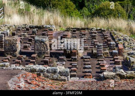 Antico sistema di riscaldamento ipocausto romano, pilastri in pietra e mattoni sollevati sopra il letto del pavimento in un sito archeologico, vista dall'alto Foto Stock