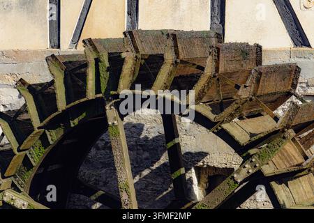 Primo piano di una vecchia ruota idraulica in legno con pale consumate e muschio Foto Stock