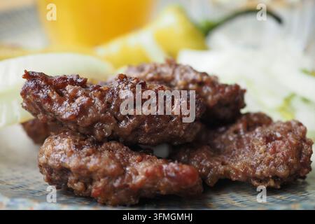 polpette turche grigliate tradizionali servite con limone e cipolle Foto Stock