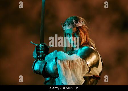 Ritratto di una donna cavaliere in armatura che tiene una spada Foto Stock