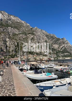 Motonavi e barche a vela ormeggiate a un molo sul lago di Garda a Limone sul Garda, Italia Foto Stock