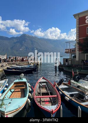Motonavi e barche a vela ormeggiate a un molo sul lago di Garda a Limone sul Garda, Italia Foto Stock