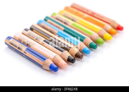 Molti pastelli di legno colorati sono disposti in una fila diagonale ordinata Foto Stock