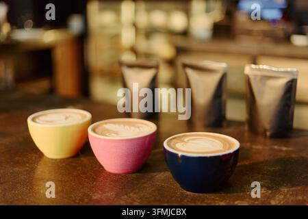 Tazze di latte appena preparato con latte art in un caffè specializzato Foto Stock