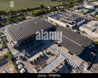 Veduta aerea di edifici commerciali con estese installazioni di pannelli solari su tetti e parcheggi ad Ancona, Marche, Italia. Foto Stock