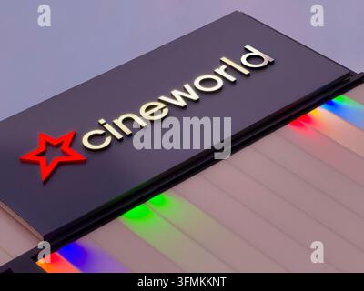 Primo piano di un'insegna illuminata del cinema Cineworld e di una colorata illuminazione esterna su un edificio moderno al crepuscolo. Foto Stock