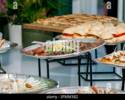 Varietà di antipasti e panini disposti su vassoi per un evento caterato. Foto Stock