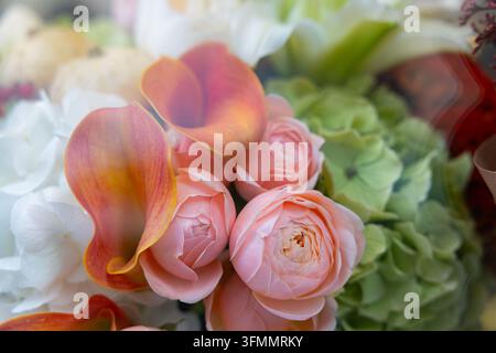 Calla arancioni con rose rosa e ortensie verdi in un delicato bouquet floreale da matrimonio scatto macro Foto Stock
