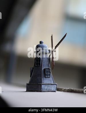 Fotografia macro in primo piano di una piccola figurina di mulino a vento vintage con sfondo sfocato bokeh. Foto Stock