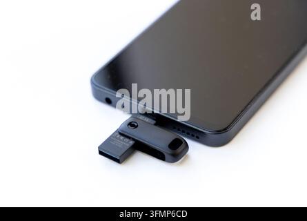 Una chiavetta USB è inserita in un telefono cellulare Foto Stock