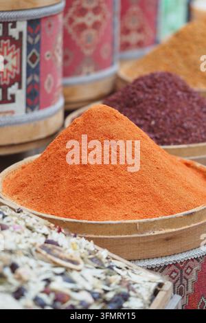 Spezie esposte in un mercato con polveri colorate e piante essiccate Foto Stock