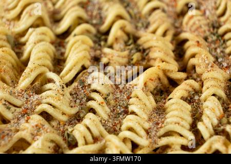 Primo piano di spaghetti istantanei crudi e ondulati ricoperti da una salsa piccante. Foto Stock