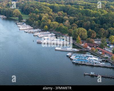 Vista aerea di barche ormeggiate lungo la riva del Treptower Park, circondate da alberi rigogliosi e vegetazione a Berlino, Berlino, Germania. Foto Stock