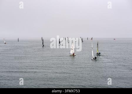 Stonehaven, Scozia, Regno Unito – 17 agosto 2025: I concorrenti navigano su dinghy attraverso acque costiere calme durante la regata dell'Aberdeen and Stonehaven Yacht Club Foto Stock