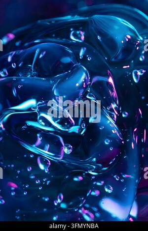 Prima abstracta di forme di vetro liquido blu e magenta lucide con bolle intrappolate, riflessi luminosi e superfici trasparenti lisce che creano un Foto Stock