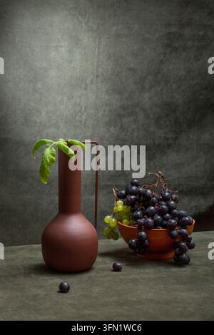 Grappoli d'uva in un piatto e in un vaso marrone Foto Stock