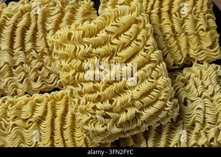 Prima di spaghetti istantanei crudi ondulati impilati insieme. Foto Stock