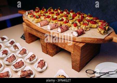 Antipasti di catering gourmet disposti su un tagliere di legno Foto Stock
