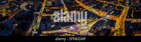 Vista aerea del centro città di Leeds dopo il tramonto con strade, passaggi ed edifici illuminati; ideale per viaggi, turismo, proprietà e pubblicità urbana Foto Stock