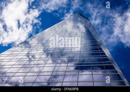 Vista architettonica a basso angolo di una facciata in vetro riflettente di un grattacielo a Madrid Foto Stock