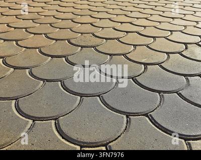 Le forme curve creano una superficie modellata in cemento in un ambiente esterno. Il pavimentazione mostra una texture interessante. Foto Stock
