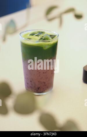 Latte ghiacciato alla fragola e matcha servito in un bicchiere trasparente Foto Stock