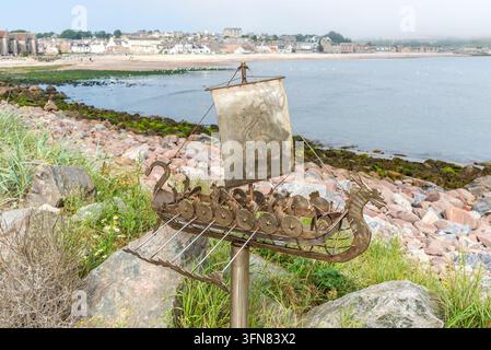 Stonehaven, Scozia, Regno Unito – 17 agosto 2025: La scultura della lunga barca vichinga dell'artista locale Jim Malcolm si trova sul lungomare di Stonehaven, affacciata su Foto Stock