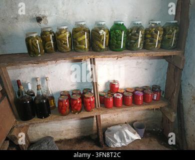 Verdure sottaceto fatte in casa conservate in barattoli di vetro all'interno di una cantina rustica Foto Stock
