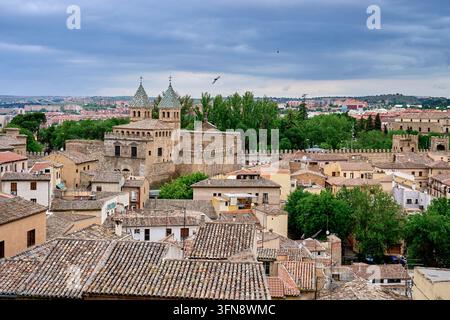 Vista sui tetti a tegole di Toledo verso la Puerta Nueva de Bisagra con le sue due torri a tegole e le mura cittadine, vista dal Cristo de la Luz, Spagna Foto Stock