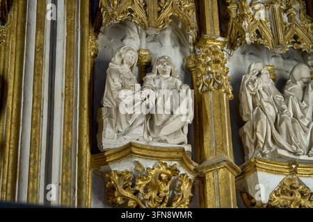 Primo piano di figure bianche scolpite in nicchie gotiche dorate nella Cattedrale di Toledo, Spagna Foto Stock