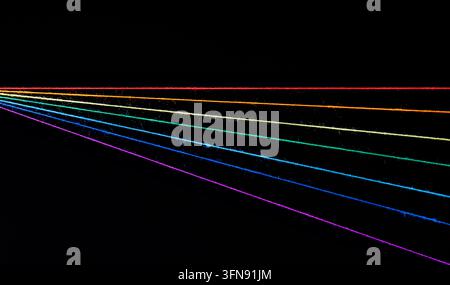 fili di cucito multicolori a forma di arcobaleno su sfondo nero in primo piano Foto Stock