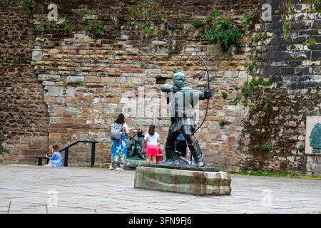Visitatori alla statua di Robin Hood fuori dal Nottingham Castle, Nottingham, Inghilterra Foto Stock