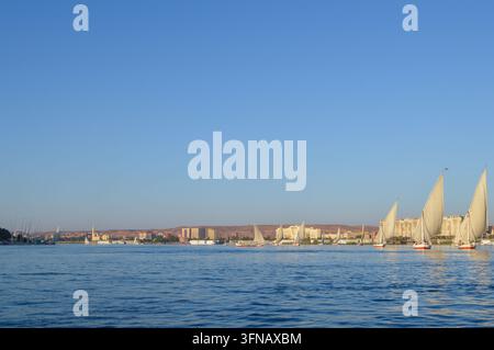 Aswan, Egitto – 1 novembre 2019: le feluche tradizionali sono ormeggiate lungo il Nilo davanti al lungofiume di Aswan. Foto Stock
