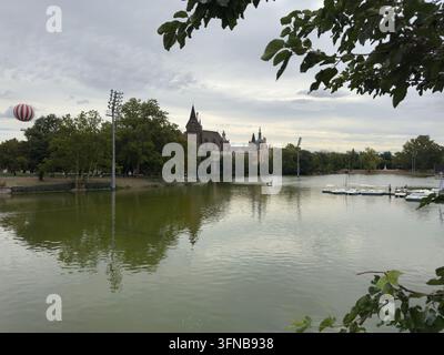 Il castello di Vajdahunyad e il pallone aerostatico che si riflette nel lago del Parco della Città Foto Stock
