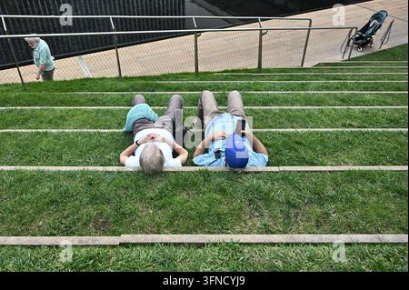 USA. 02 ottobre 2026. Due persone si riposano sul Laurie M. Tisch Illumination Lawn al Lincoln Center mentre le temperature raggiungevano i 80 gradi, portando una sensazione estiva a New York City, N.Y., il 2 ottobre 2026. (Foto di Anthony Behar/Sipa USA) Credit: Sipa USA/Alamy Live News Foto Stock