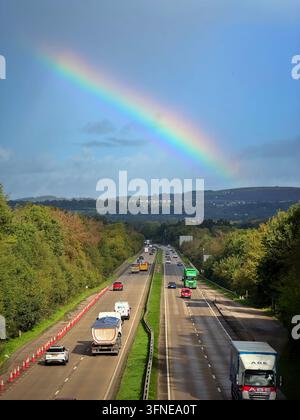 Arcobaleno su una strada a doppio corridoio trafficata (A4232), Galles, Regno Unito Foto Stock