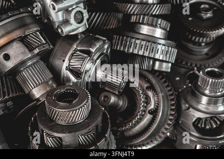 Primo piano di vari ingranaggi di trasmissione di auto usate e componenti meccanici in officina Foto Stock