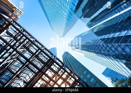 Vista ad angolo basso dei grattacieli del centro finanziario del centro di Toronto, con torri in vetro riflettente, architettura in acciaio e cielo blu brillante sopra Foto Stock