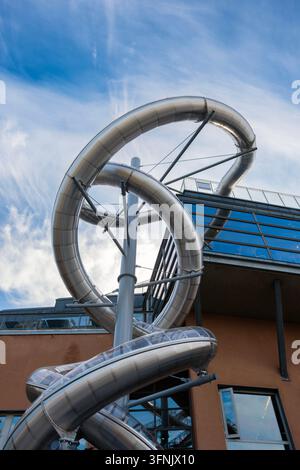 Ripresa a basso angolo della gigantesca scultura a forma di scivolo a spirale in acciaio inossidabile montata sulla facciata moderna del Moderna Museet sull'isola di Skeppsholmen Foto Stock