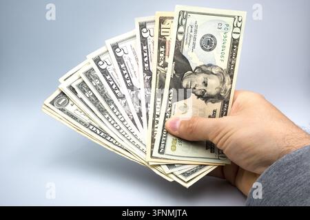 Dollari tenuti nella mano di un uomo. Foto Stock