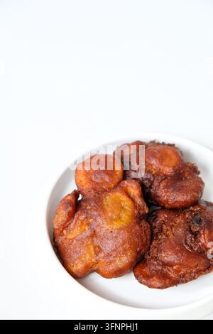 Deliziose banane fritte croccanti con semi di sesamo servite su un piatto bianco Foto Stock
