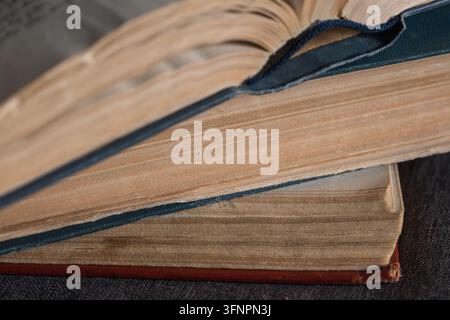 Due vecchi libri con uno aperto, che rivela pagine consumate e scolorate e una texture dettagliata della carta invecchiata Foto Stock