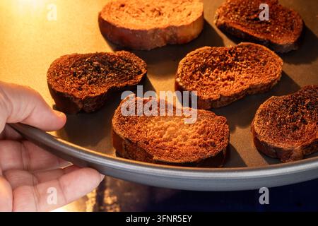 Fette di pane tostato bruciate dentro un forno, pane troppo cotto e carbonizzato Foto Stock